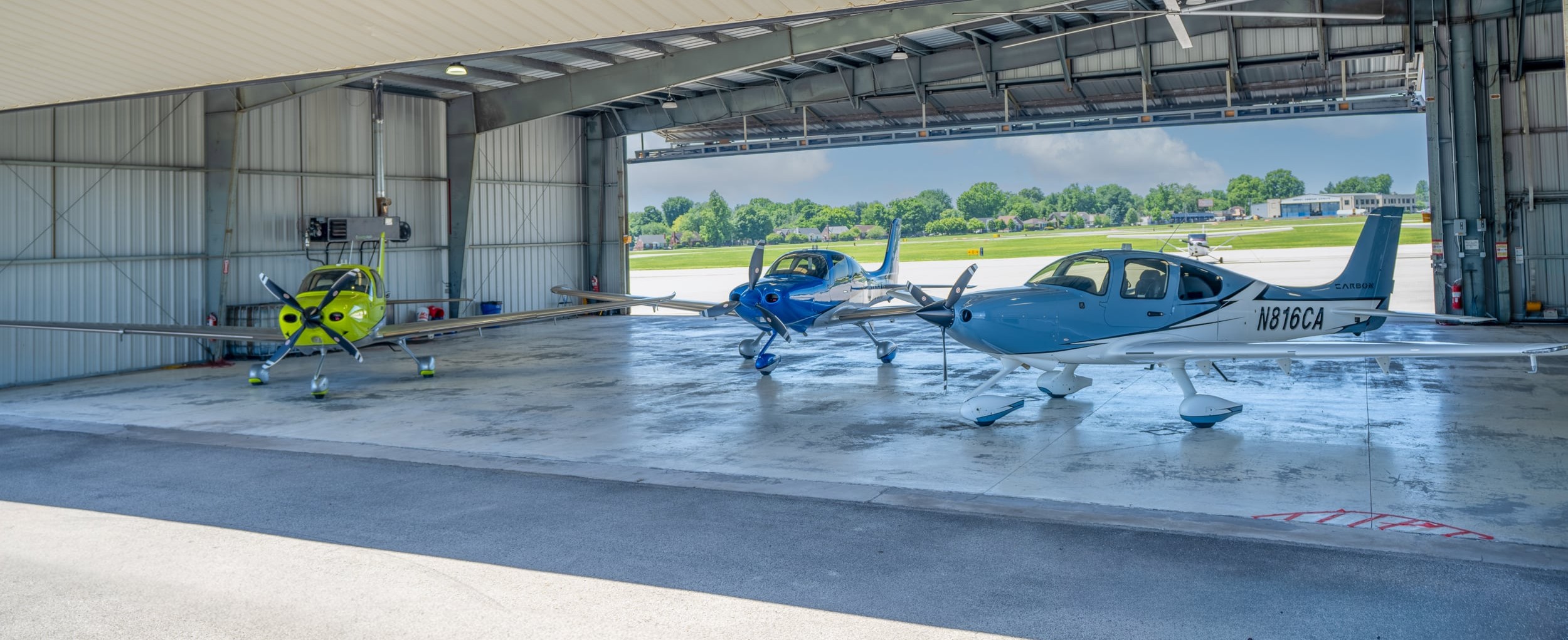 Three Cirrus aircraft in the hangar at the historic Bowman Field, Louisville