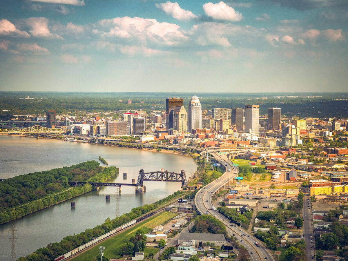 Aerial view of the Louisville skyline and the Ohio River railway bridge in golden evening light